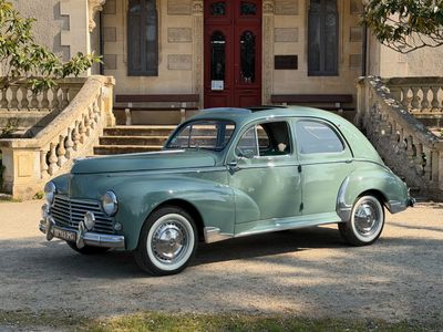 une voiture verte garée devant un immeuble