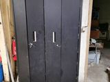a black metal cabinet in a garage with a box on top of it