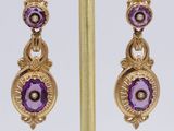 pair of amethorate and diamond earrings on a gold plated stand