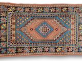 un tapis bleu et orange orné d'un motif en médaillon