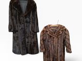two fur coats on a hanger and a coat on a hanger