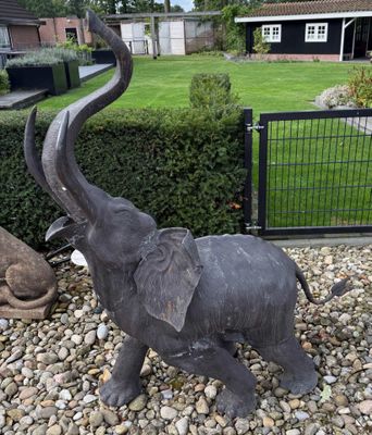a statue of an elephant and a statue of an elephant in a garden