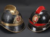 pair of firemen ' s helmets on a black background
