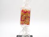 a bag of food wrapped in plastic on top of a black stand