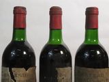 three bottles of wine are lined up on a table