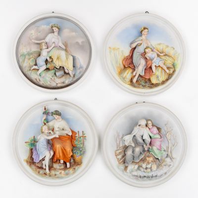 quatre assiettes en porcelaine sur lesquelles figurent une femme et un enfant