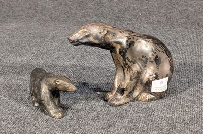 deux figurines représentant un ours et son ourson, posées sur un tapis