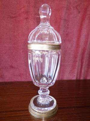 a glass jar with a gold lid on a wooden table