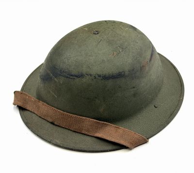 an old army helmet with a brown ribbon on a white background