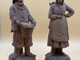 two figurines of women standing next to each other