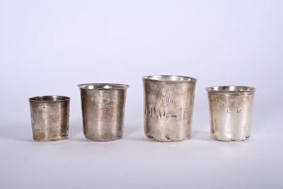 quatre coupes en argent sont alignées sur une surface blanche