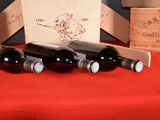 several bottles of wine sit on a red table cloth next to wooden crates