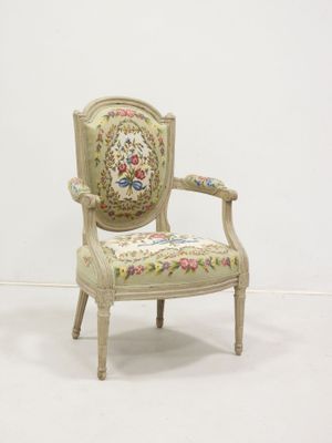 a white chair with a floral upholstered back and arms