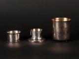 three silver cups sitting next to each other on a table