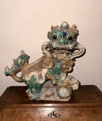 une statue représentant un dragon perché sur une caisse en bois