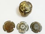 quatre morceaux de vieux métal posés sur une surface blanche