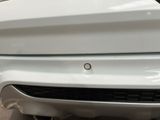 a close up of a car ' s bumper with a small hole in it