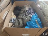 a cardboard box full of clothes on the floor