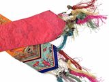 a pink bag with a tassel hanging from it ' s side