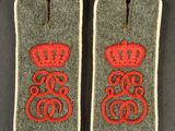 two military badges with red thread and a crown on them