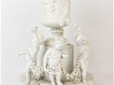 a white vase that has a statue on top of it