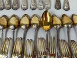 a lot of silver spoons and forks on the table