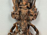 une photo représentant une statue d'une personne posée sur une table en bois