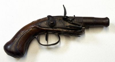 un pistolet posé sur une surface blanche