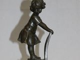 une statue représentant une petite fille assise sur une chaise
