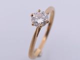a gold engagement ring with a single diamond