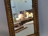 a mirror sitting on a table with candles in the background