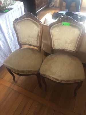 Trois chaises sont posées sur le parquet d'un salon.
