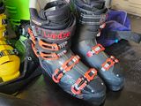 many ski boots that are lined up on the floor