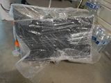une pile de bouteilles d'eau emballées dans du plastique, posée par terre