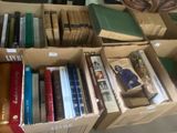 des boîtes de livres sont empilées dans une pièce