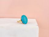 a close up of a turquoise stone ring on a marble block
