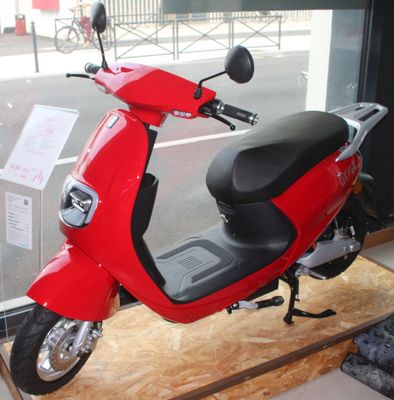 un scooter rouge garé devant une fenêtre