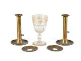 trois bougeoirs et un verre à vin sur fond blanc