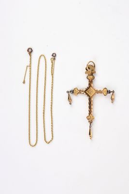 two gold crosses and a chain on a white surface