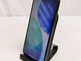 a close up of a cell phone on a stand on a white surface