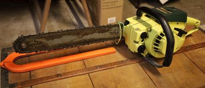 une tronçonneuse posée sur une table en bois