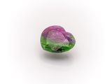 a close up of a pink and green stone on a white surface