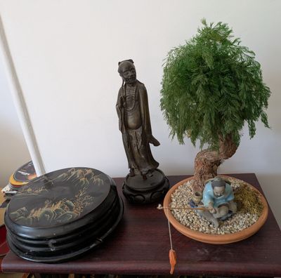 une table sur laquelle se trouvent une plante en pot et une statue