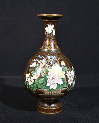 un vase sur lequel sont peintes des fleurs sur fond noir