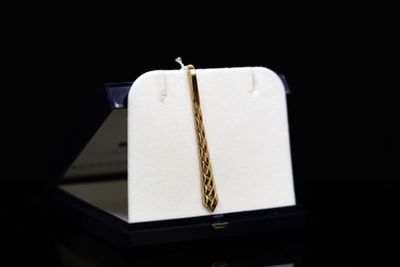 an image of a gold tie on a black background
