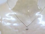 silver plated necklace with a diamond pendant on a mannequin torso