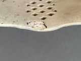 a white plate with holes in the middle of it