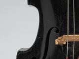 a close up of a black violin with red strings on a white background