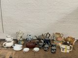 many different types of teapots and cups on the table