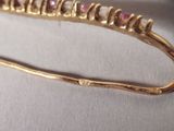an image of a gold bracelet with pink stones on it